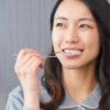 デンタルフロスを使って歯間ケアをする女性